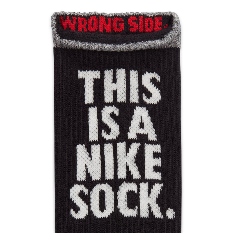 Black crew sock cuff with gray trim; red 'WRONG SIDE' and white 'THIS IS A NIKE SOCK'