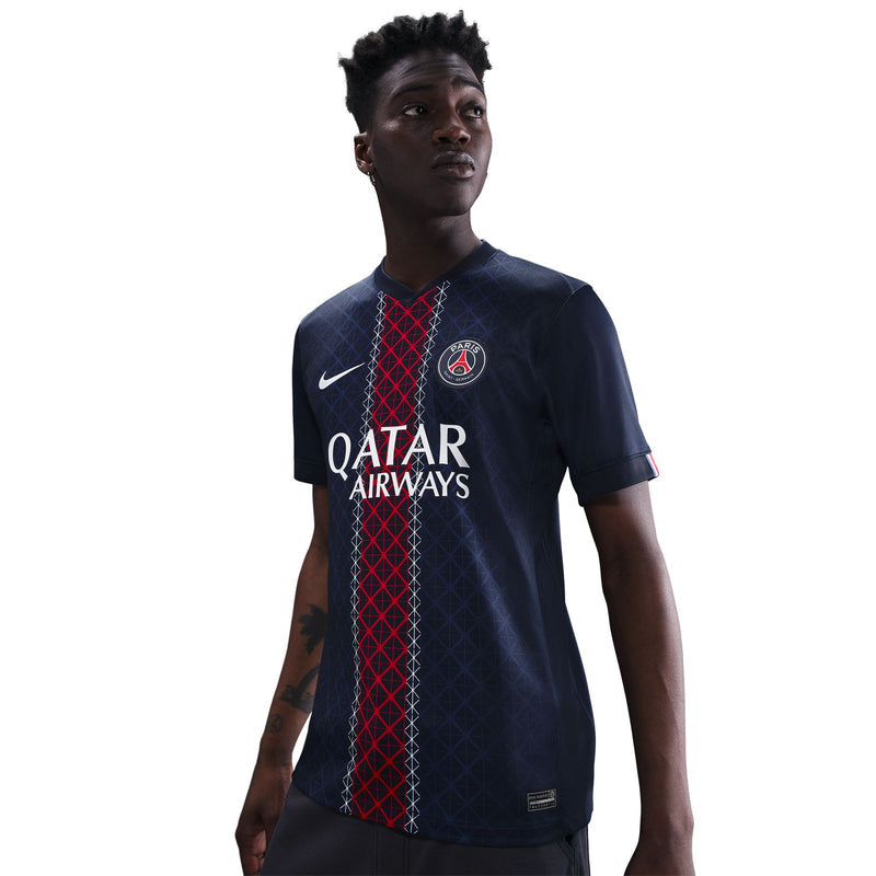 Men's PSG stadium home jersey on model, navy with QATAR AIRWAYS and red vertical design