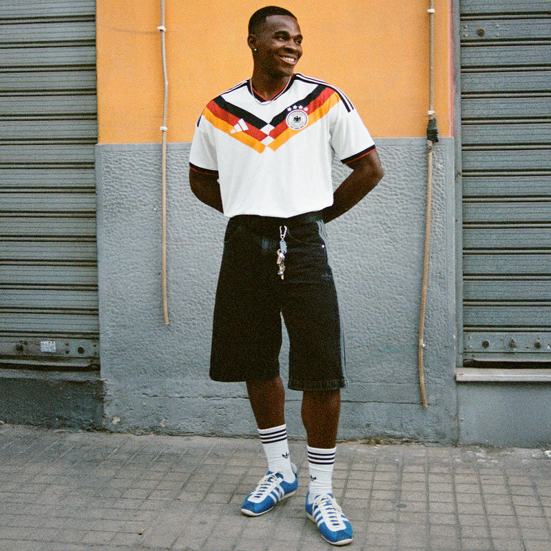 Men's white Germany home soccer jersey with multicolor V graphic and short sleeves