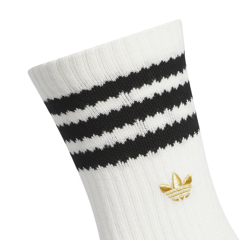 White crew sock cuff with black stripes and gold logo badge