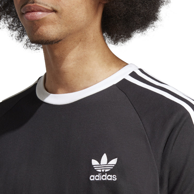 Close-up of adidas logo on black T-shirt with white 3-stripe collar trim