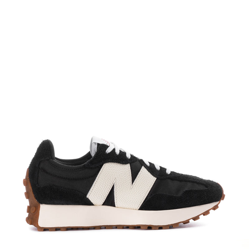 Women's black-and-white sneaker with white N logo, black laces, and gum rubber sole.