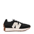 Women's black-and-white sneaker with white N logo, black laces, and gum rubber sole.
