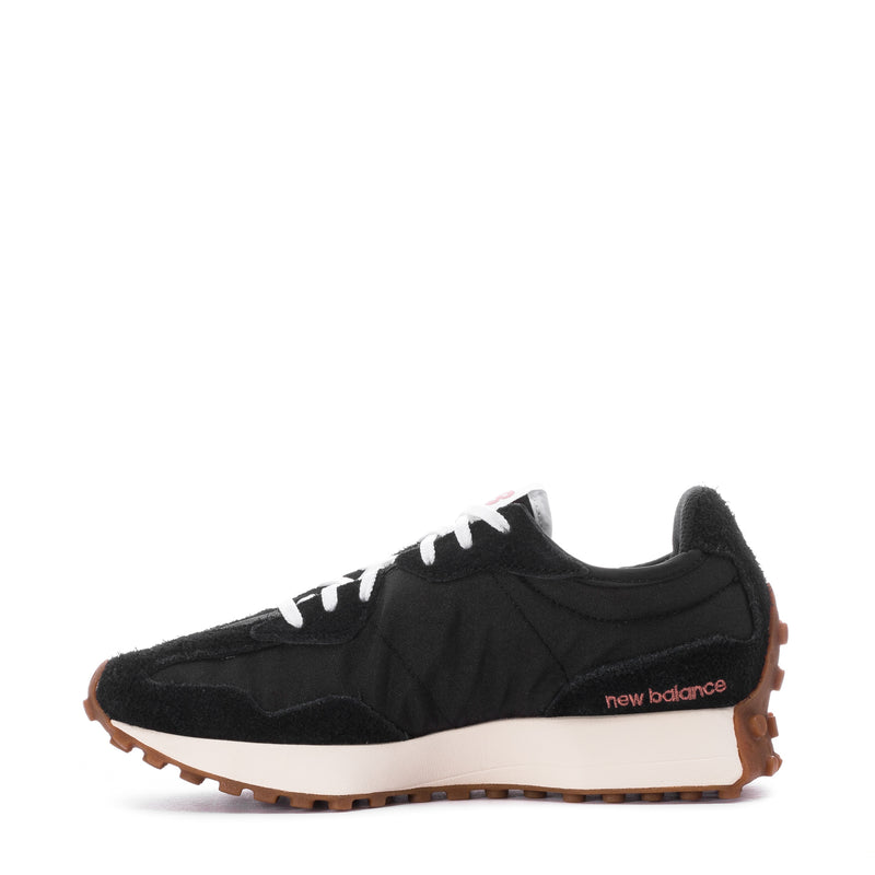 Women's black sneaker with white laces, 'new balance' side text, and gum sole.