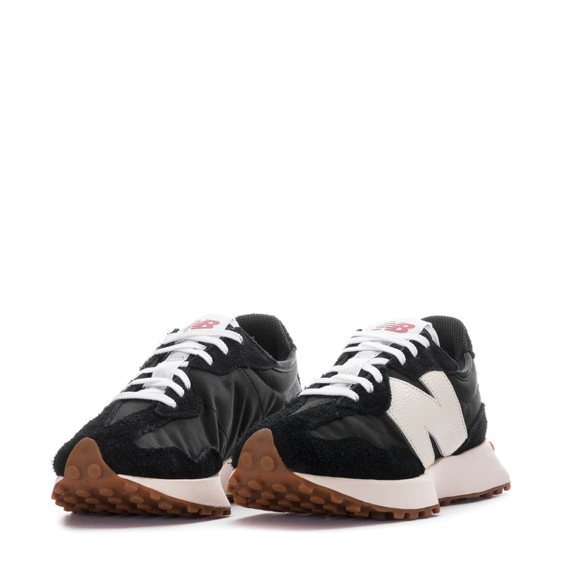 Pair of women's black-and-white sneakers with white laces and gum rubber soles.