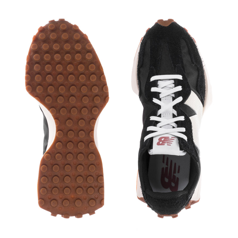 Women's sneaker outsole with tread and black upper with white laces and N logo.