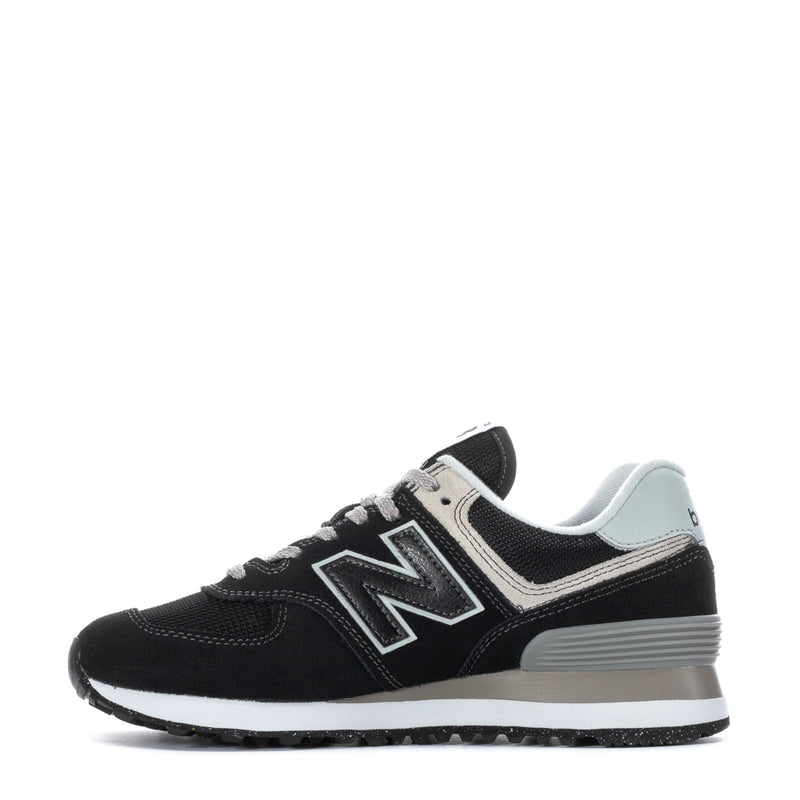 Women's black and white New Balance 574 sneakers, side view with white trim
