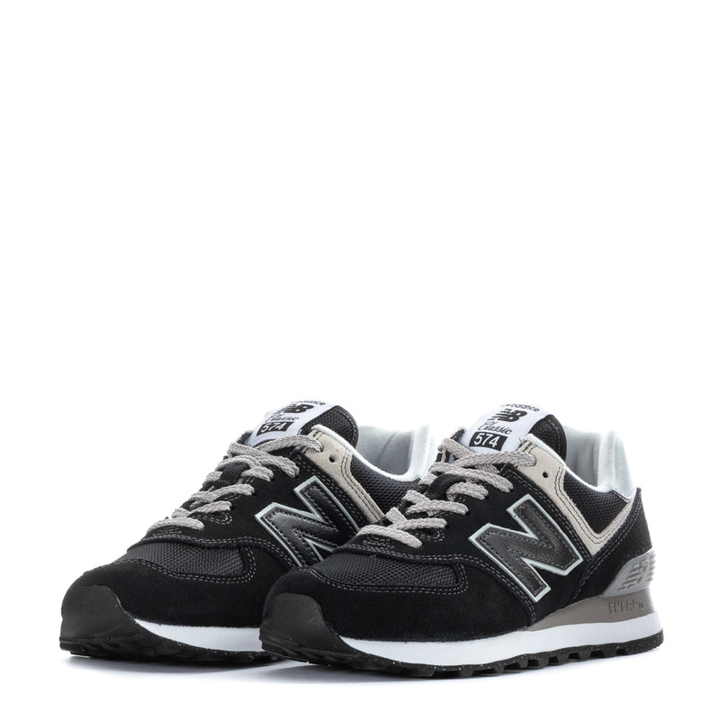 Women's black and white New Balance 574 sneakers, front pair with light collar
