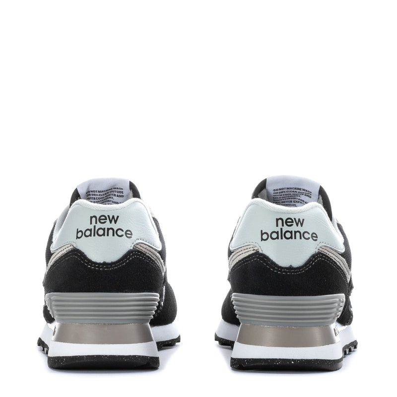 Women's black and white New Balance 574 sneakers, back view with "new balance" heel