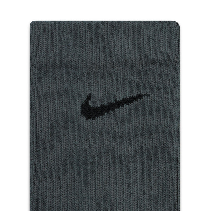 Dark gray crew sock fabric close-up with small swoosh-style logo on cuff