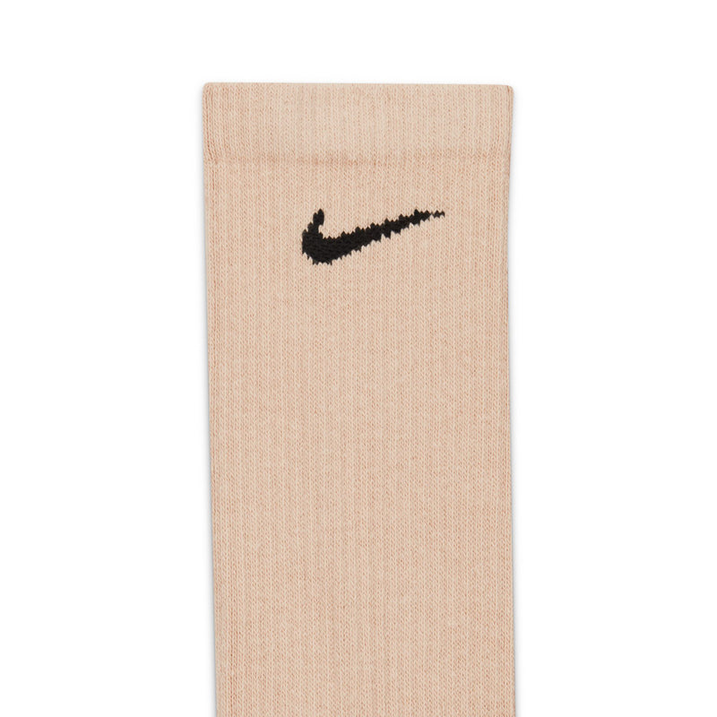 Cream crew sock close-up, black Nike swoosh on ribbed knit