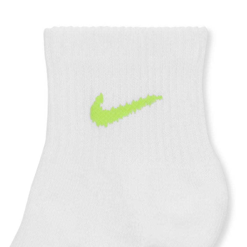 White quarter sock close-up with lime green swoosh logo at ankle cuff