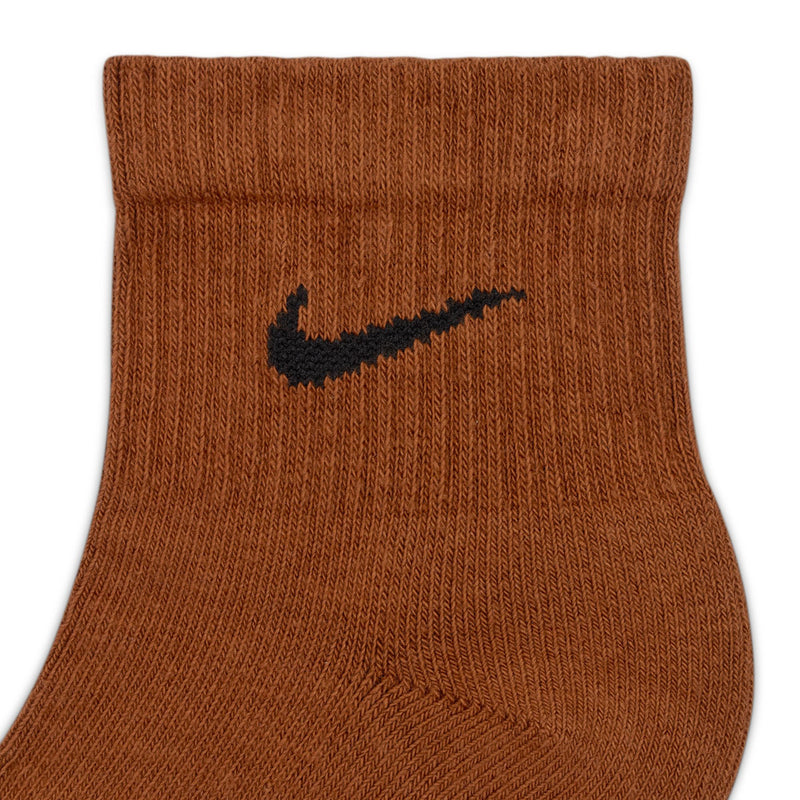 Cushioned quarter sock close-up in brown knit, black Nike swoosh on front