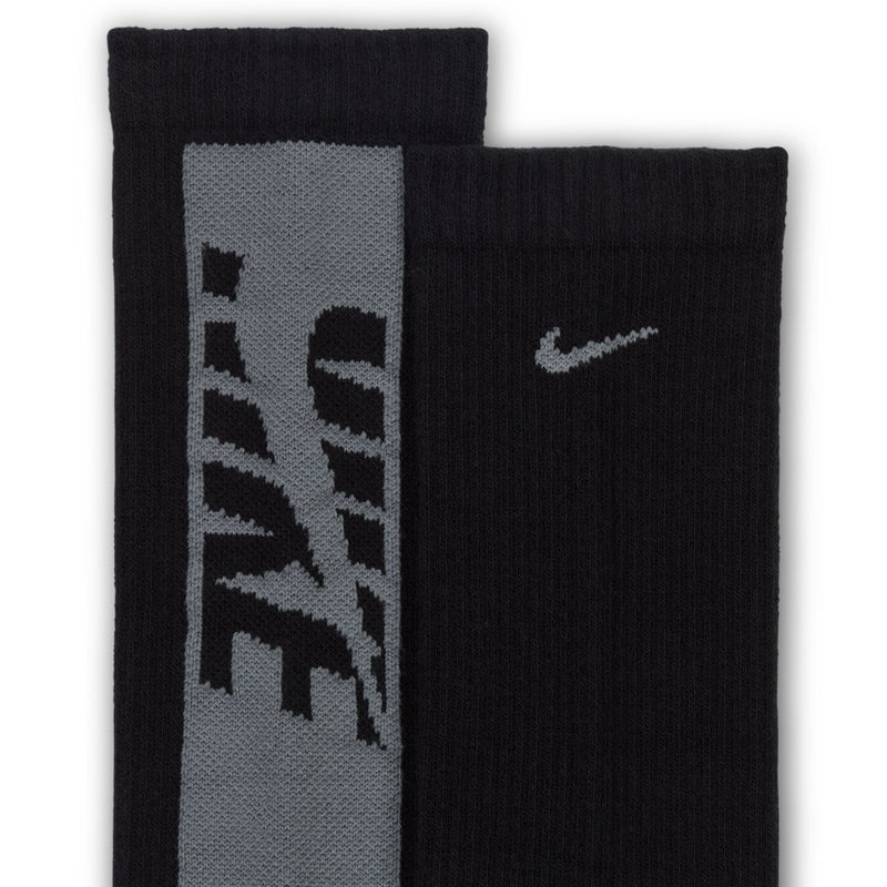 Youth crew socks close-up in black and gray with large graphic panels and a swoosh