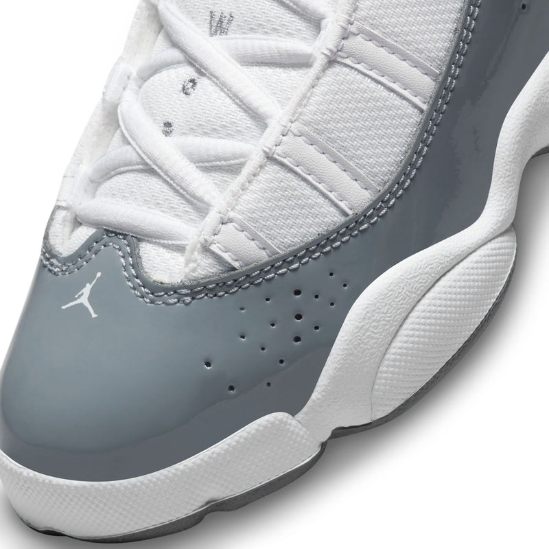 Kids' sneaker upper detail in white and cool grey, perforations, stitching, and lace loops