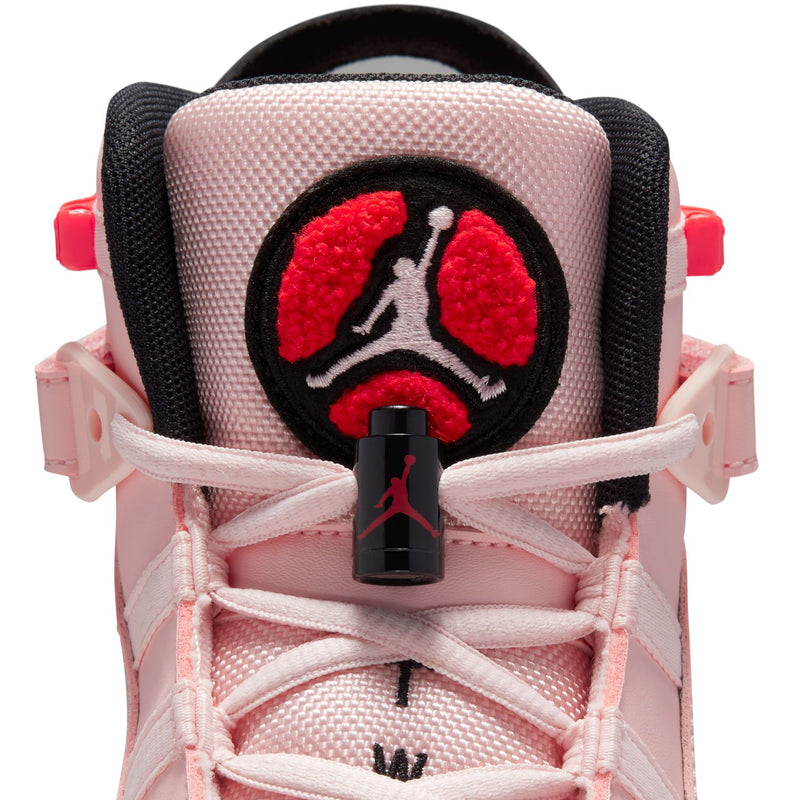 Close-up of pink sneaker heel with black circular patch and red Jumpman graphic