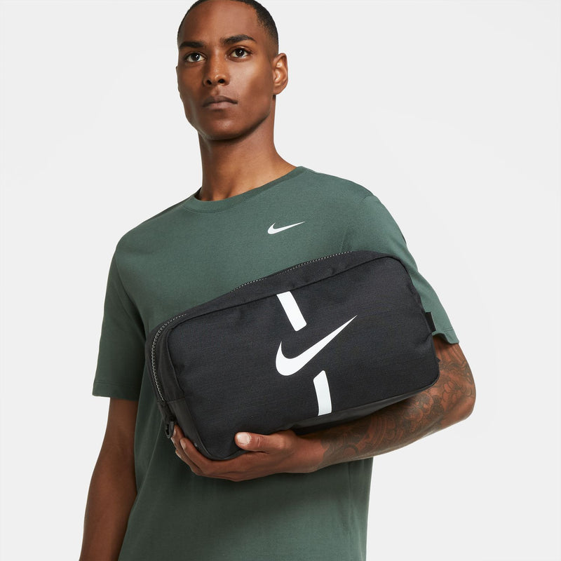 Black soccer shoe bag with white Nike swoosh, held in hand