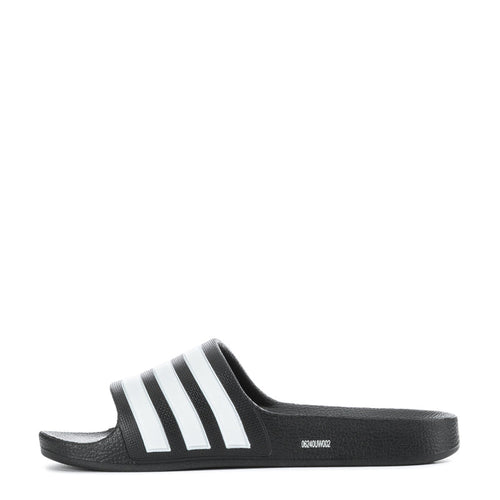 Kids black slide sandals with white triple stripes, side profile
