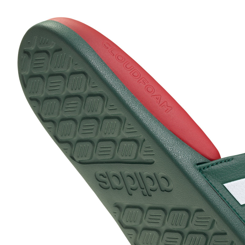 Close-up of green traction outsole and red midsole edge on men's slide sandals