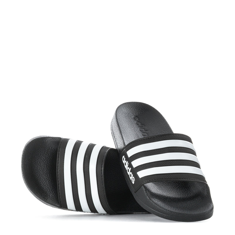 Kids black slide sandals with three white adidas stripes