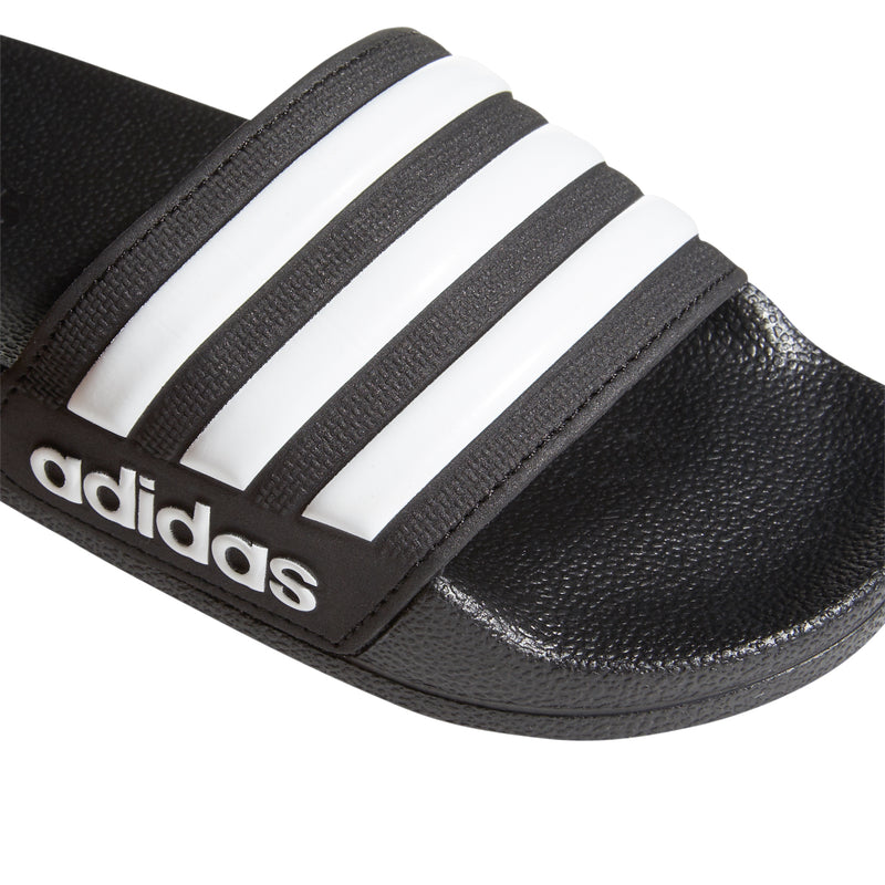 Close-up of black slide sandal strap with white three stripes and adidas logo