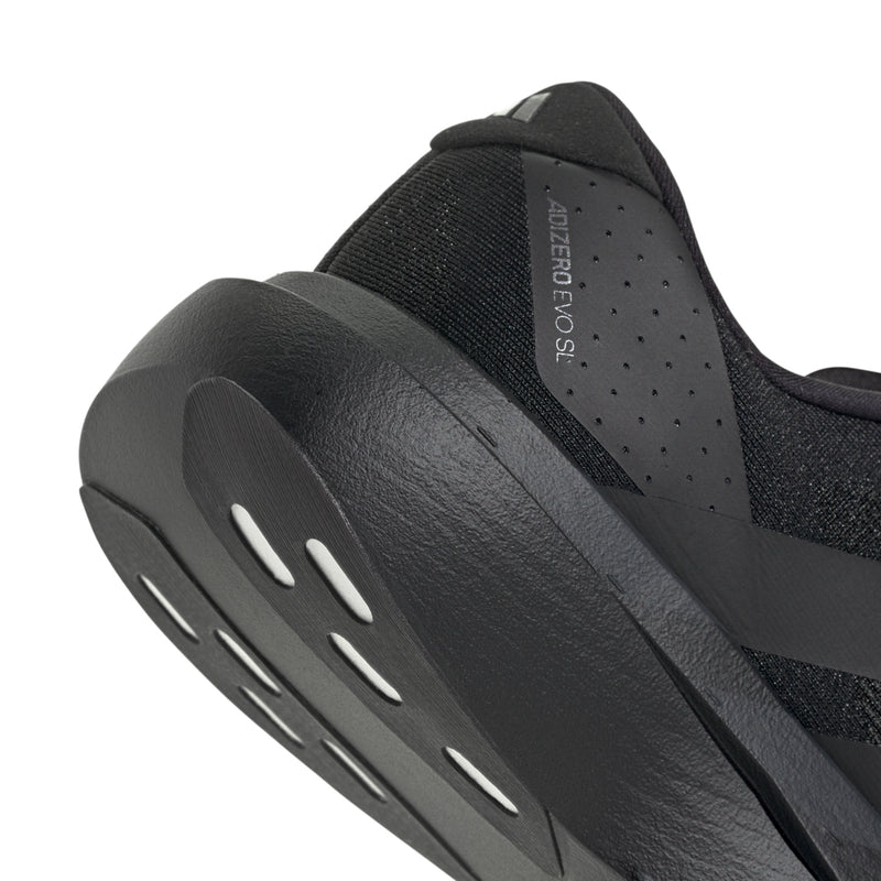Black shoe side view with slotted midsole cushioning and perforated panel