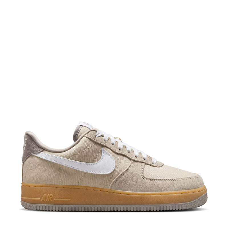 Nike Air Force 1 low-top sneakers in light khaki with white swoosh and gum outsole.