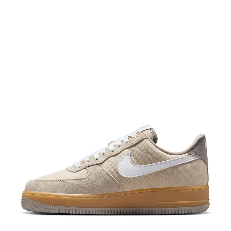 Nike Air Force 1 low-top sneakers side view, light khaki upper with white swoosh.