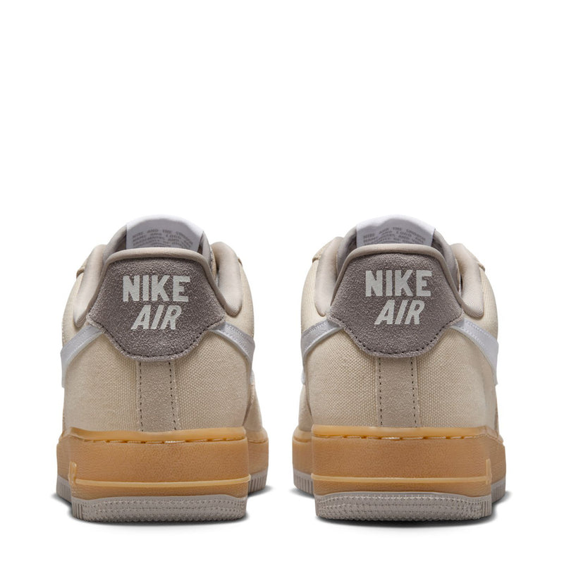 Nike Air Force 1 sneakers heel view, light khaki upper with Nike Air heel logo.