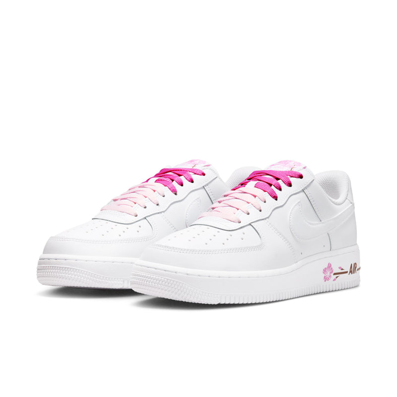 Women’s white low-top sneakers with pink lace-up and swoosh detail
