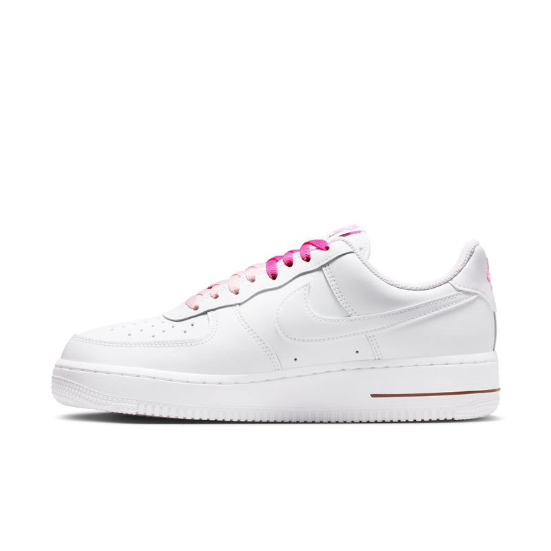 Women’s white low-top sneakers with pink laces and brown accent stripe
