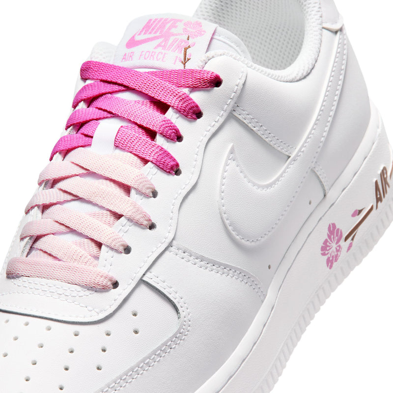 Close-up of white upper with pink laces, lace loops, and floral Nike Air tag