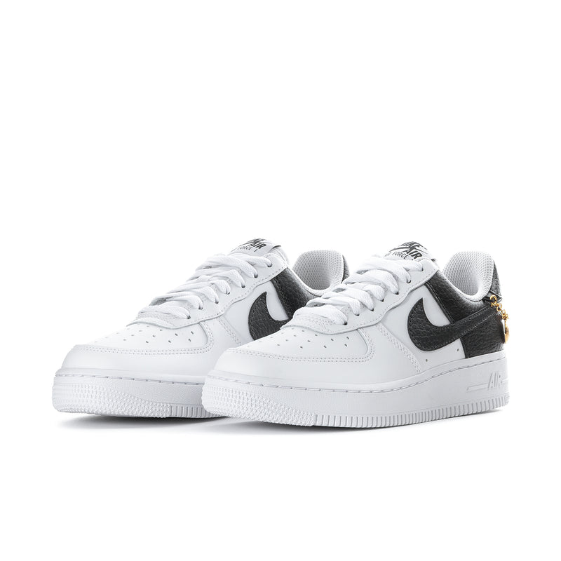 Women's low-top sneakers, white leather upper with black swooshes and gold chain details
