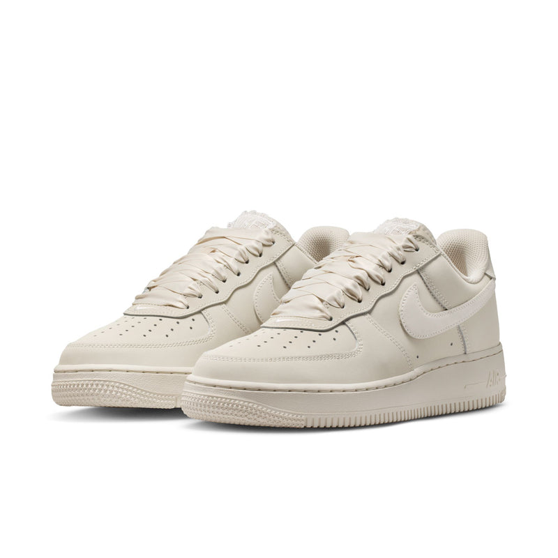 Pair of Women's Nike Air Force 1 sneakers, light oatmeal with lace-up closure