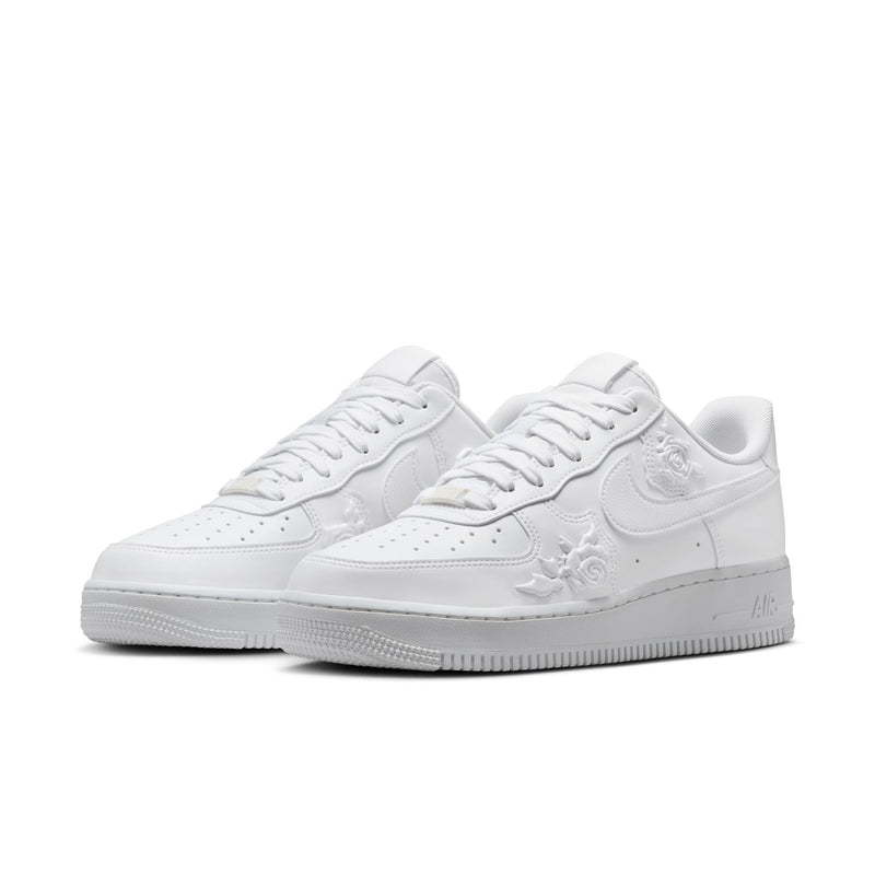 Women's Nike white low-top sneakers, side view with floral embossed accents
