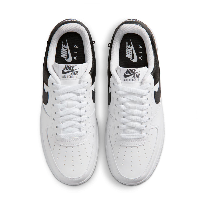 Pair of women's white sneakers with black heel tabs and Nike Air Force 1 lettering