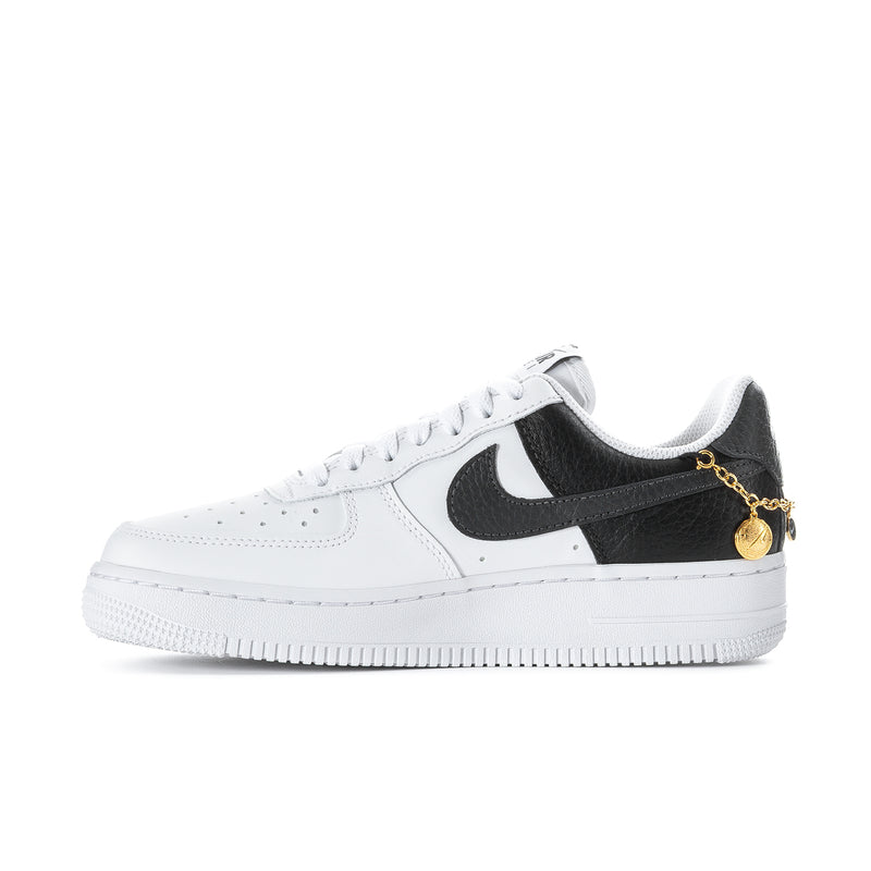 Women's low-top sneakers with white leather, black swoosh, and gold chain lariat detail