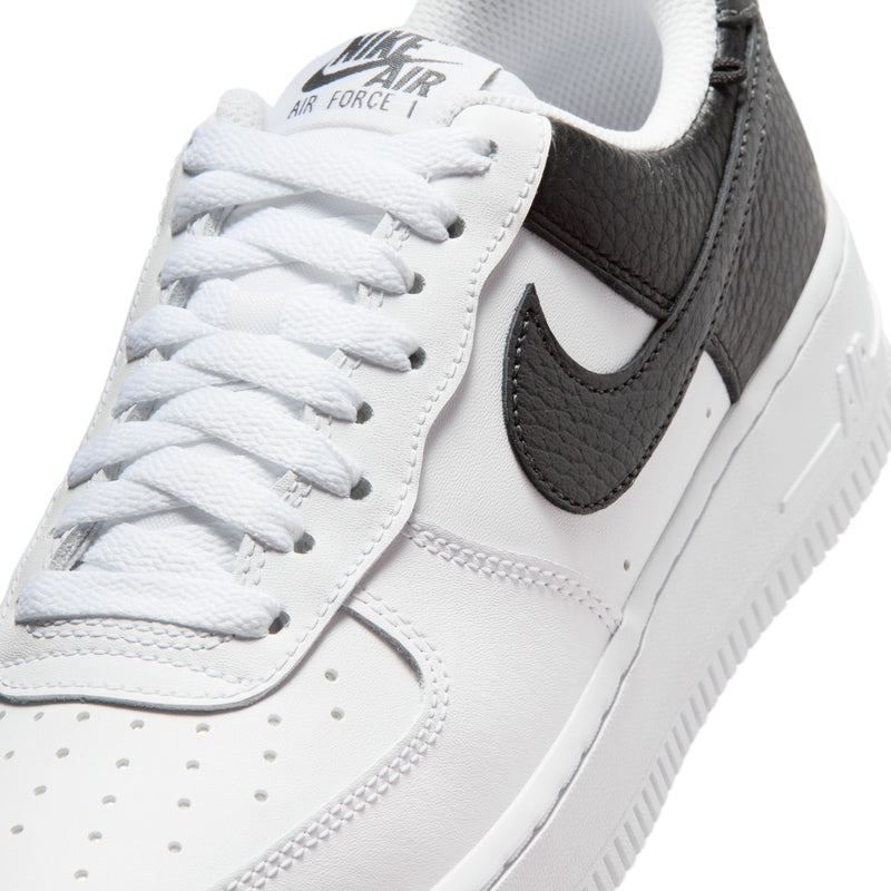 Women's sneaker upper close-up in white with black Nike swoosh and white laces