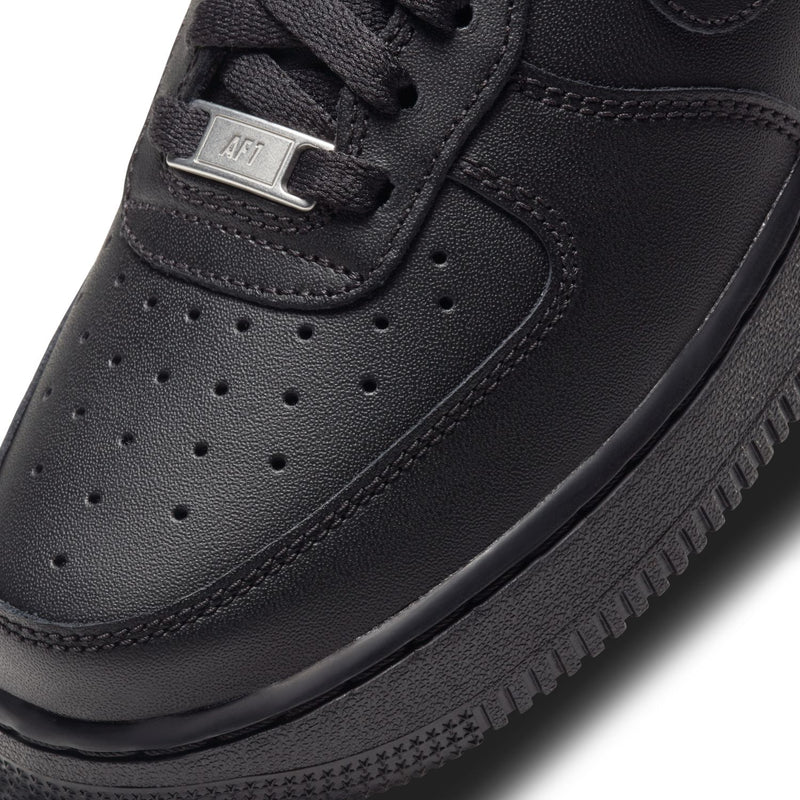 Black leather-look sneaker upper close-up, perforated toe and lace hardware