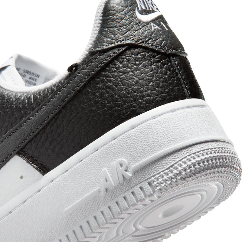 Women's sneaker side close-up in black leather with white midsole and Air logo