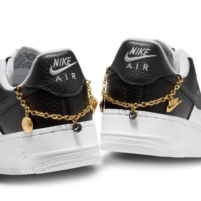 Women's sneakers heel close-up: black collar, gold chain charms, and Nike Air tab