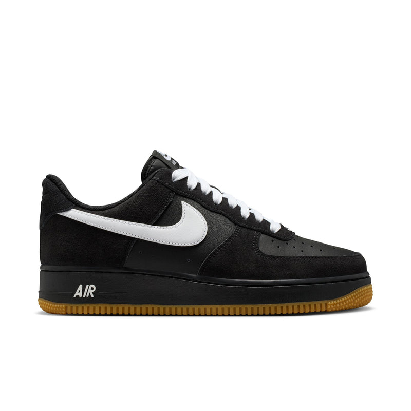 Black low-top sneakers with white swoosh, gum outsole, and Air logo on the side.