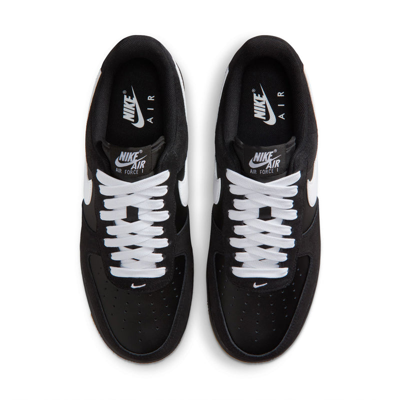 Black sneakers with white laces and tongue branding, viewed from above.