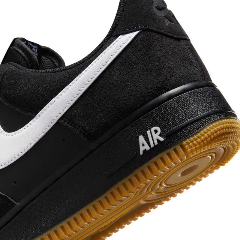 Black sneaker with white side stripe, Air heel detail, and gum outsole edge.