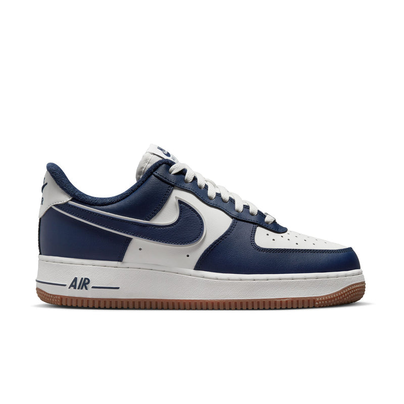 Low-top sneakers in navy and white with gum rubber sole and swoosh accents