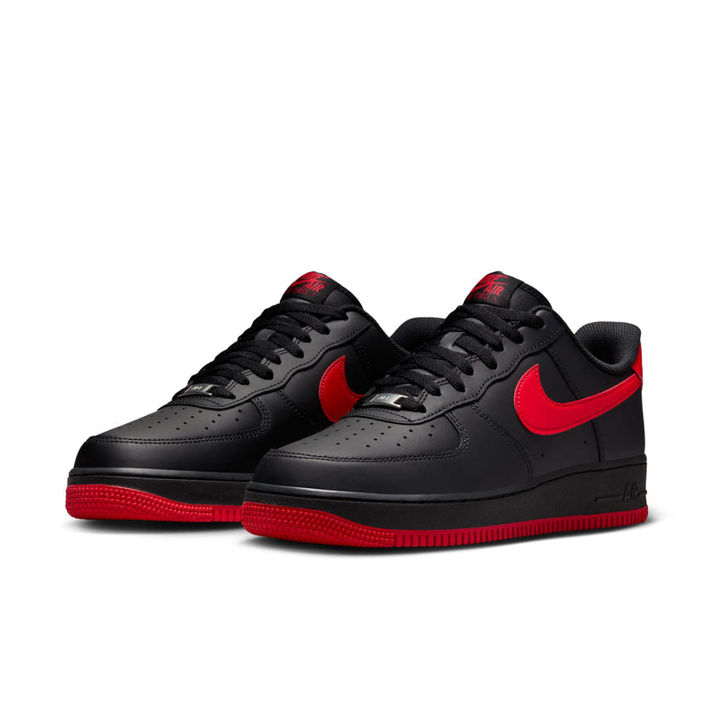 Pair of black low-top Nike sneakers with red swooshes and red outsoles