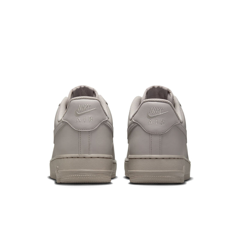 Light gray low-top Nike sneakers from heel view with Air logo on back