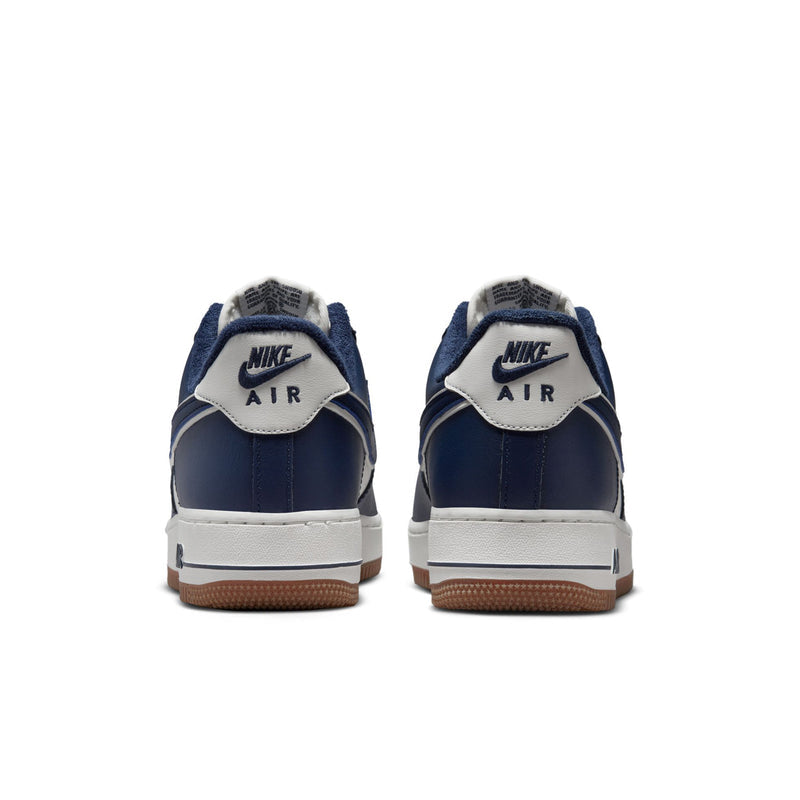 Back view of navy and white low-top sneakers with gum outsole