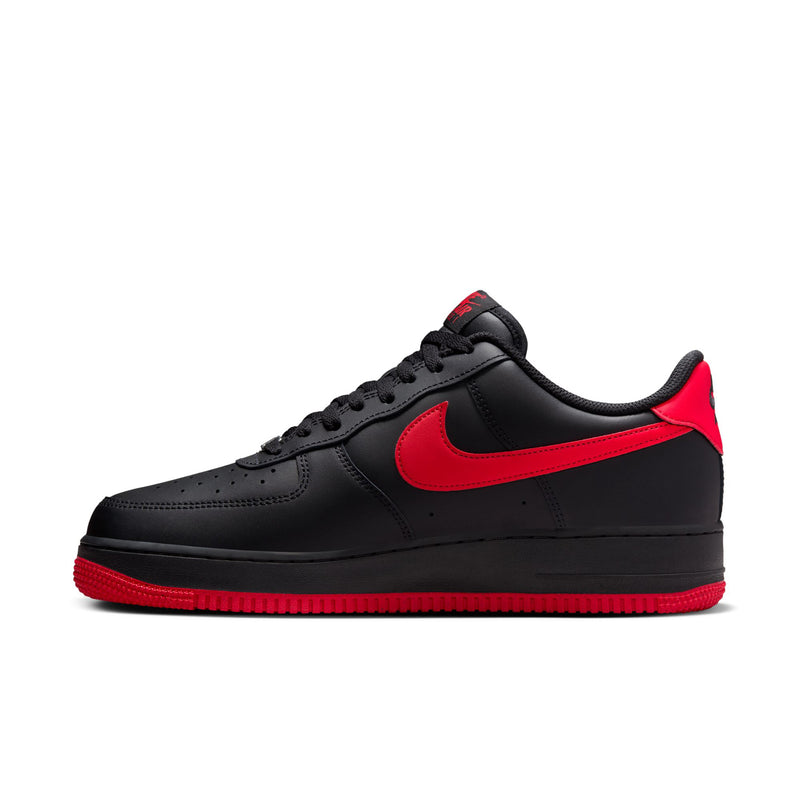 Black low-top Nike sneaker with large red swoosh and textured toe box