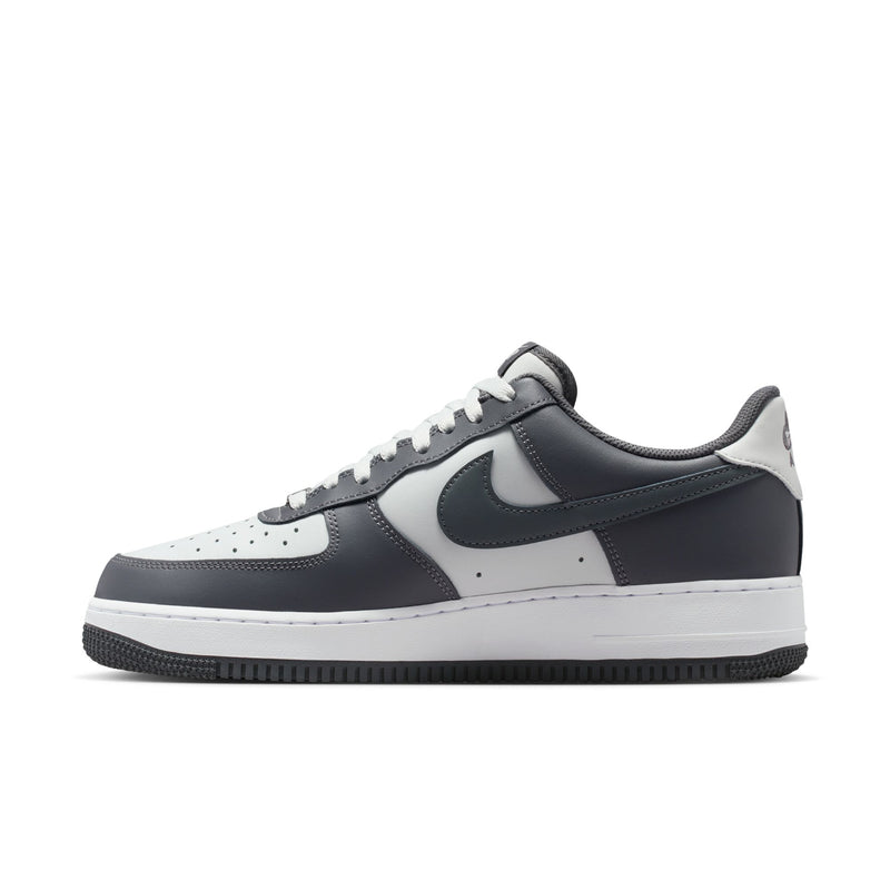 Single men's low-top sneaker side view in dark grey and white with swoosh